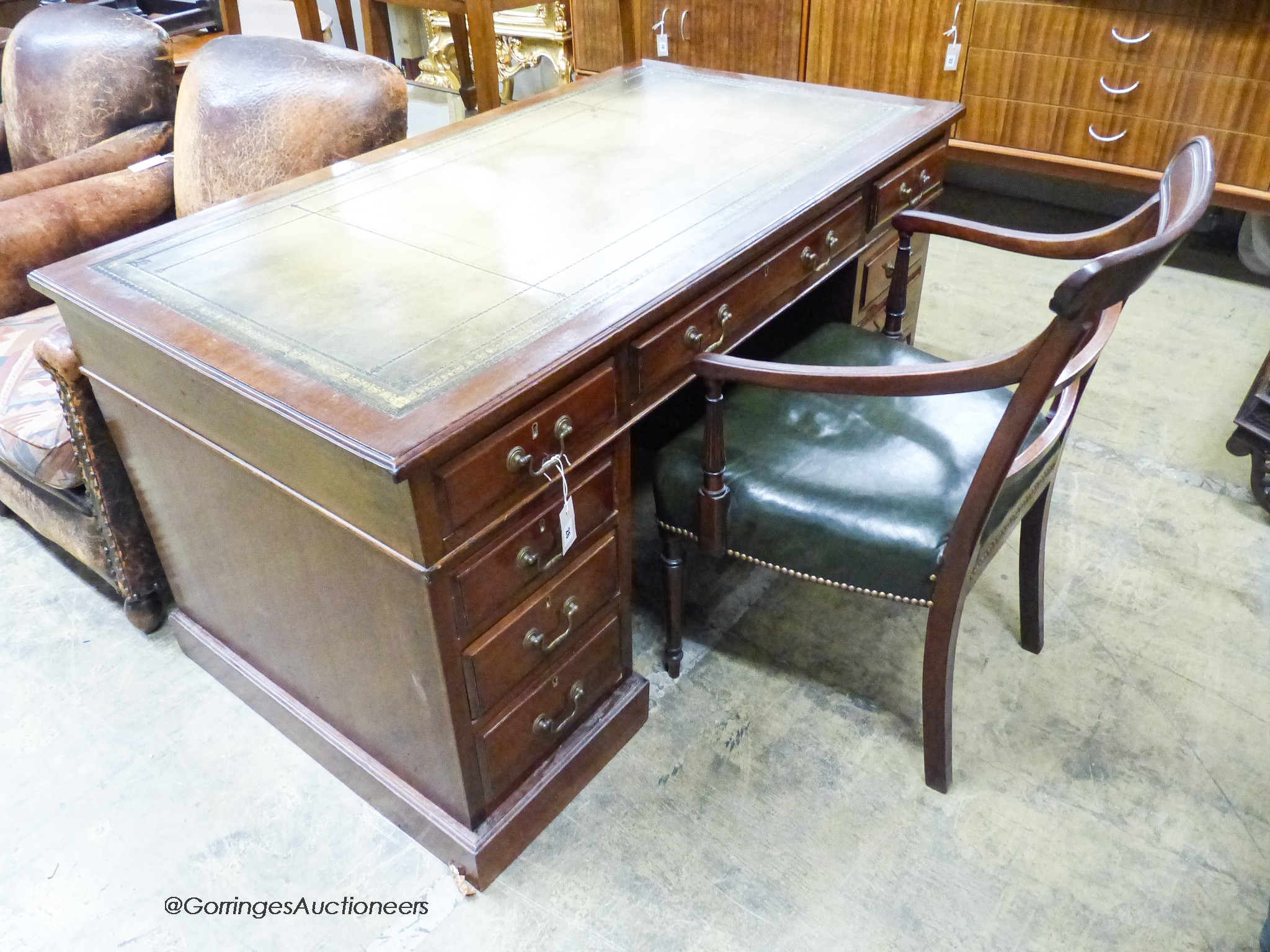 An Edwardian mahogany pedestal desk, length 138cm, depth 75cm, height 74cm together with a George III mahogany elbow chair